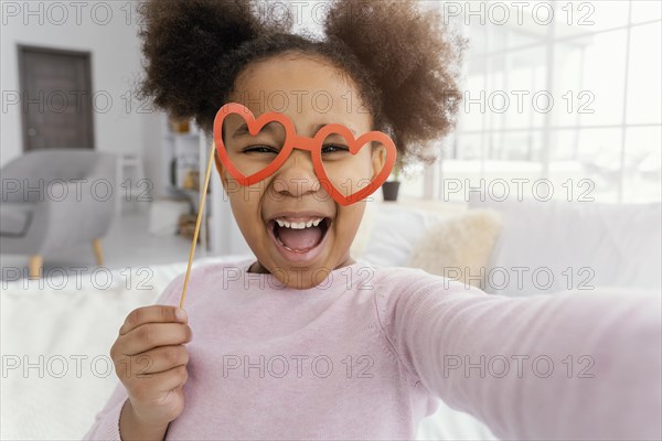 Front view little girl taking selfie home