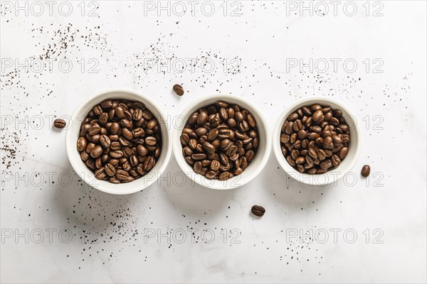 Top view three cups with roasted coffee beans