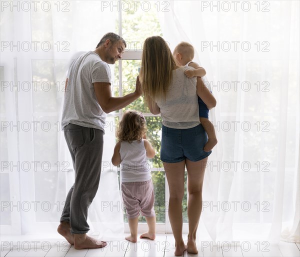 Back view family members looking out window