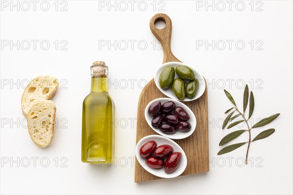 Flat lay bread slices purple red green olives with olive oil bottle