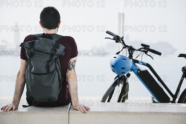 Back view man sitting his e bike