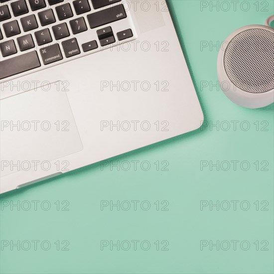 Close up bluetooth speaker laptop green background