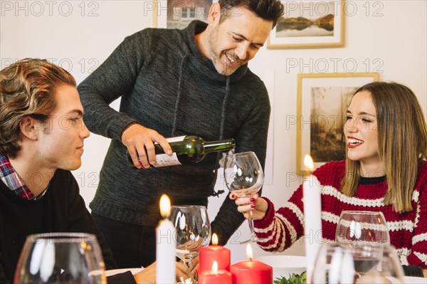 Man filling wine glass christmas dinner