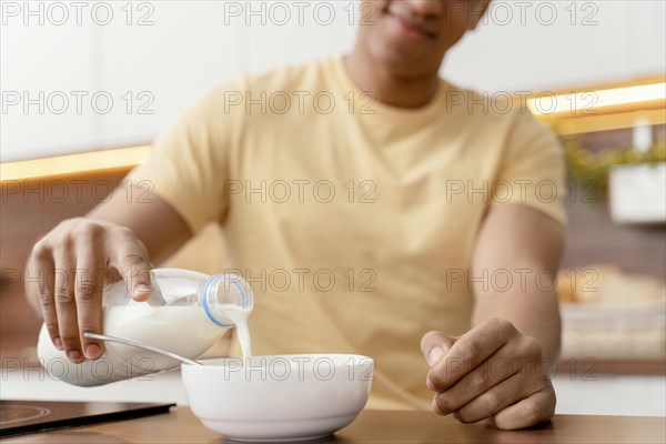 Portrait man home pouring milk bowl