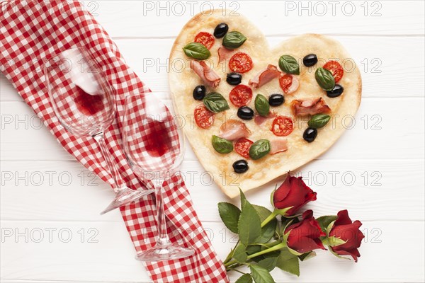 Top view heart shaped pizza with wine