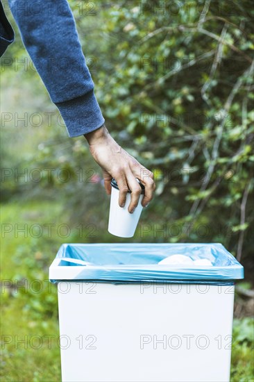 Man throwing up garbage bin