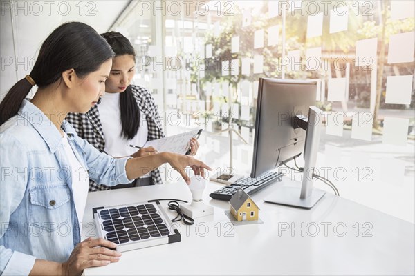 Asian women working hard together indoors