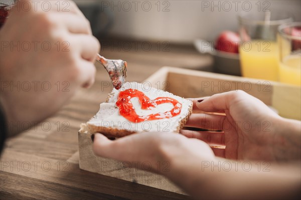 Crop couple making toast with jam