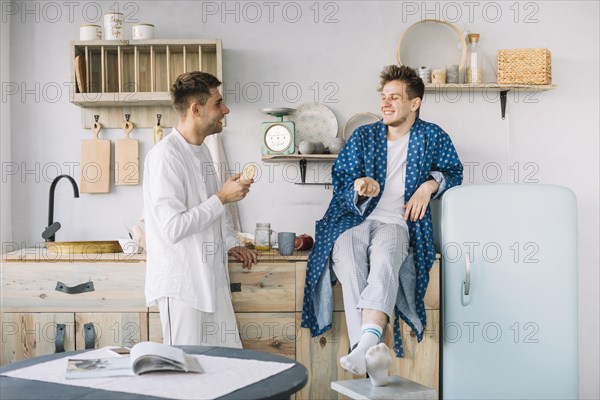 Two happy man having morning breakfast kitchen