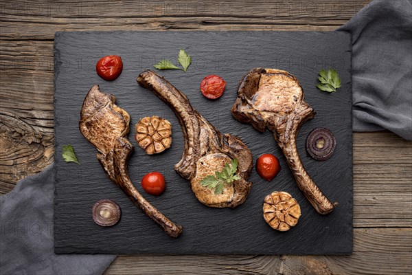 Wooden board with cooked meat vegetables