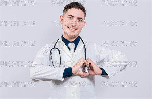 Young latin doctor making heart shape on isolated background. Friendly doctor making heart gesture with hands isolated