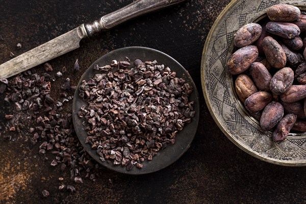 Top view grounded cocoa beans plate with knife cocoa beans