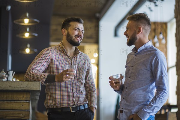 Man with his friend holding glass whiskey bar