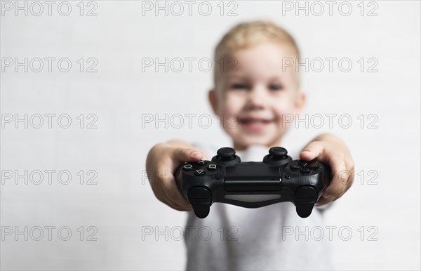 Unfocused little boy holding controller
