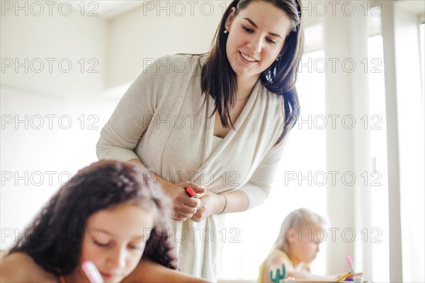 Female teacher leaning schoolgirl