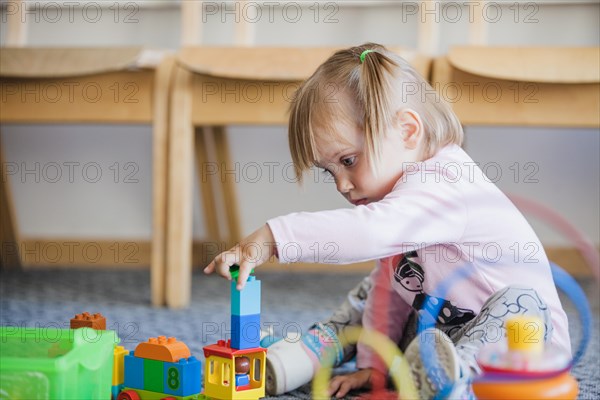 Girl stacking toys playroom