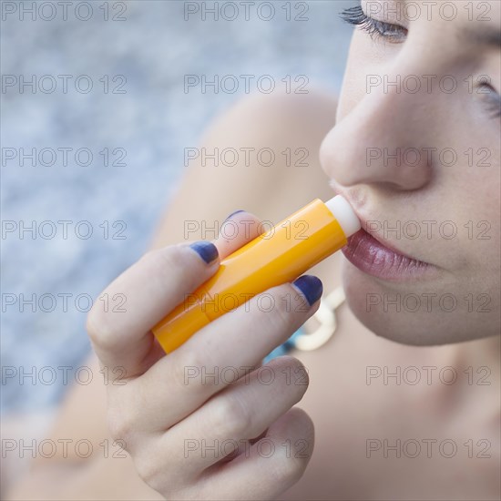 Overhead view young woman applying lip balm