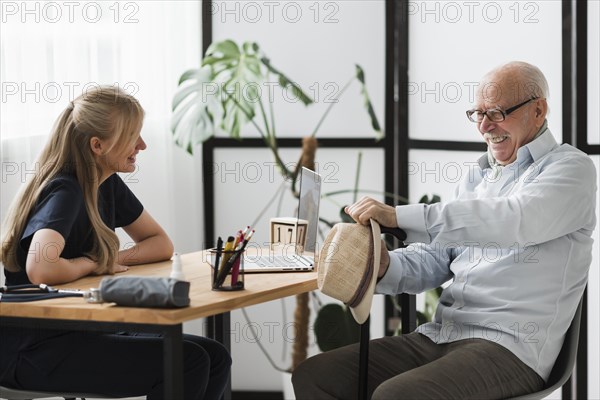 Smiley senior man nursing home with nurse