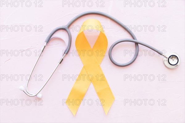 Sarcoma bone cancer yellow ribbon with stethoscope pink background