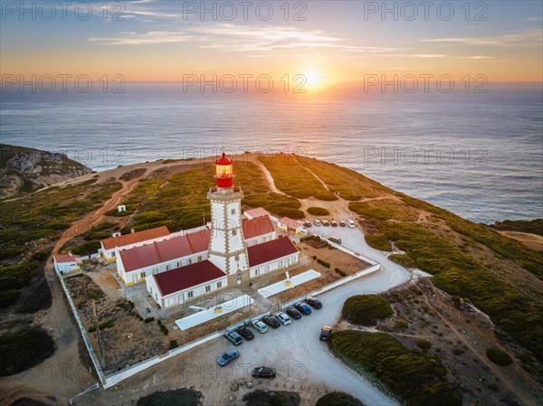 Aerial drone view of lighthouse on Cabo Espichel cape Espichel on Atlantic ocean at sunset. Sesimbra