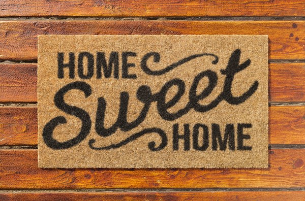 Overhead of home sweet home doormat on the wood plank porch