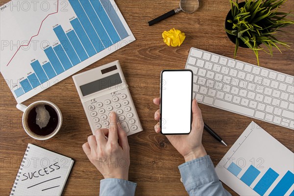 Top view office desk with growth chart hands using calculator