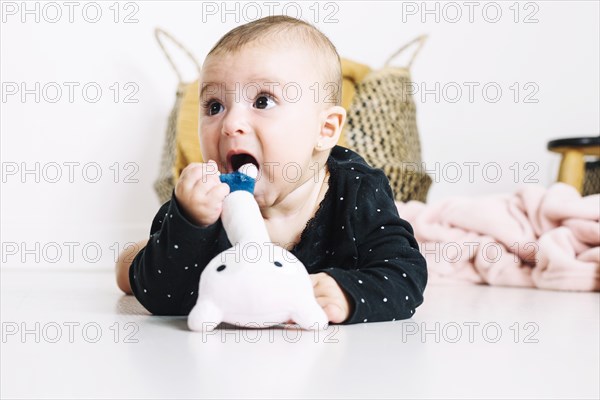 Cute baby trying bite toy