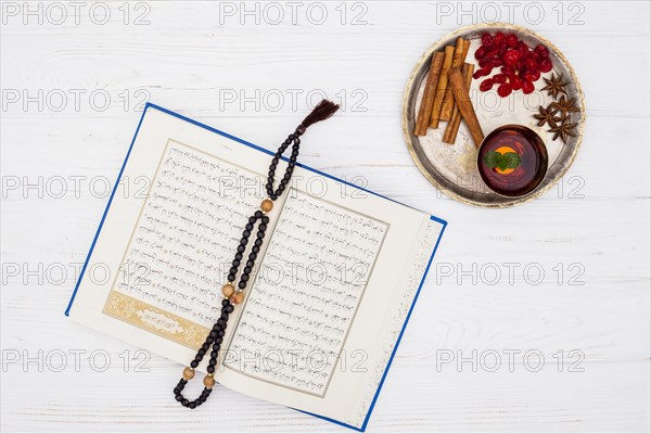 Cup tea near spices tray book with beads