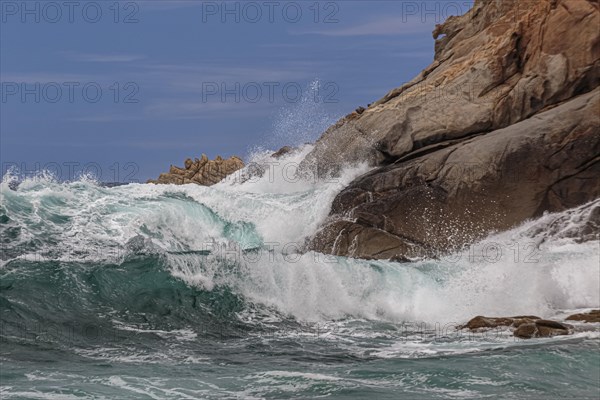 Waves crash against the rocks of the coast in a storm