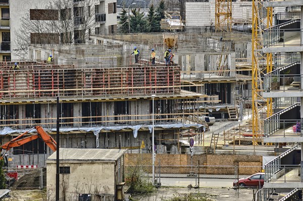 Construction workers install formwork and iron rebars or reinforcing bar for reinforced concrete partitions at the construction site of a large residential building. Construction process