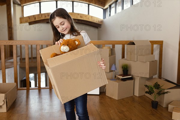 Girl holding box with toy medium shot