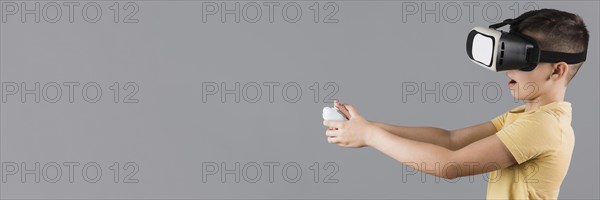 Side view boy using virtual reality headset with copy space