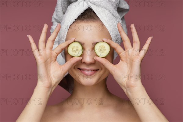 Beautiful woman using cucumber slices eyes