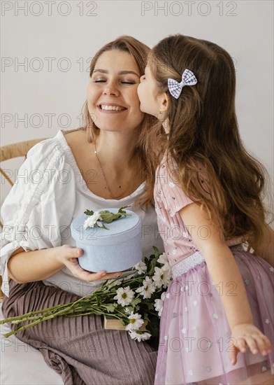 Little girl giving spring flowers gift box her mom mother s day