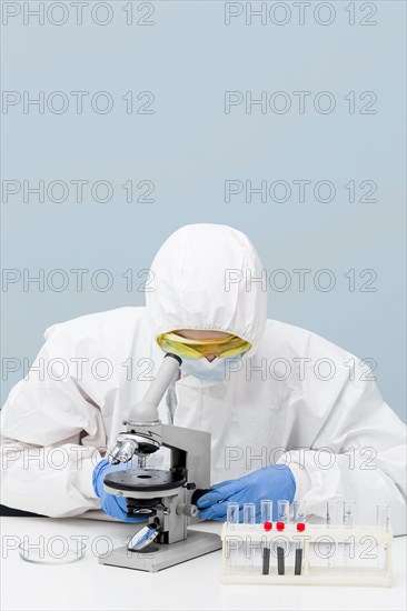 Scientist looking through microscope with copy space