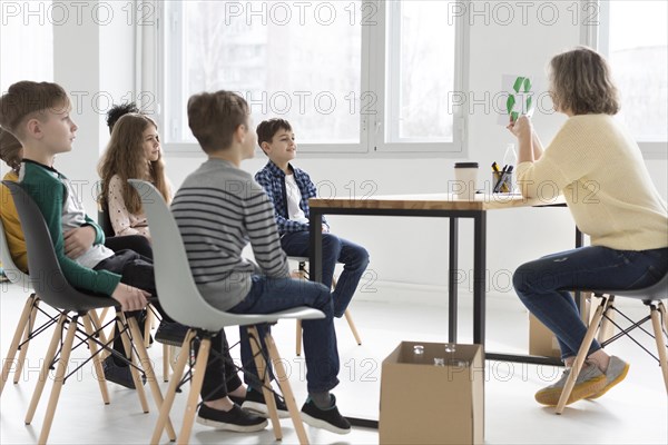 Teacher showing children how recycle