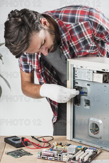 Young male technician examining computer workshop