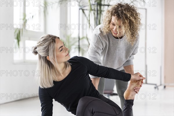 Woman doing yoga with teacher