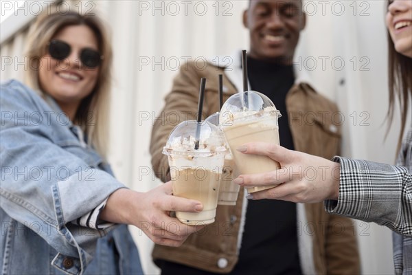 Friends hanging out while enjoying cup coffee