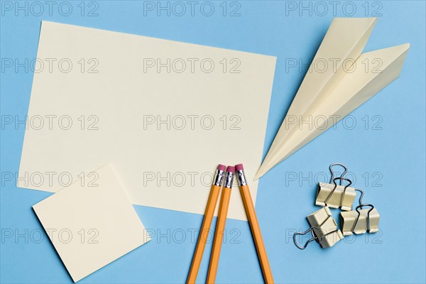 Top view paper plane with pencils desk