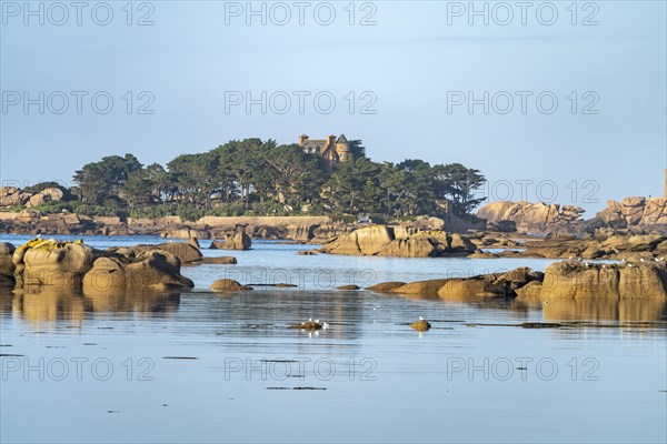 The rocks of the pink granite coast Cote de Granit Rose at the Baie de Sainte Anne near Tregastel and Costaeres Castle