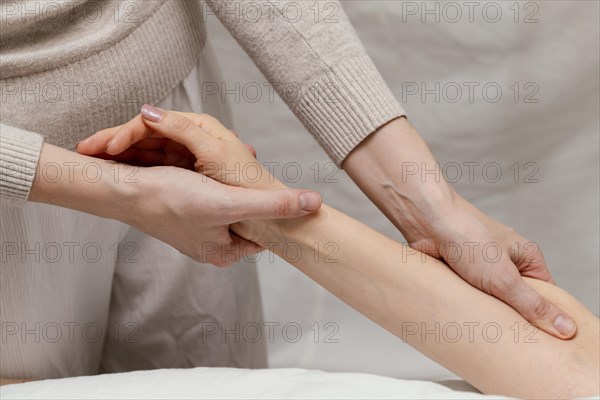 Close up therapist massaging patient s arm