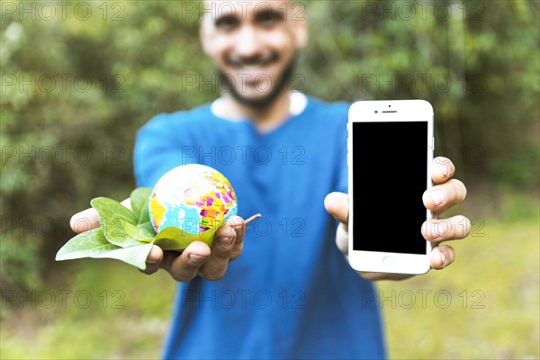 Man holding globe with leaf smartphone