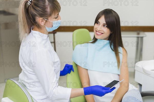 Dentist happy patient looking each other