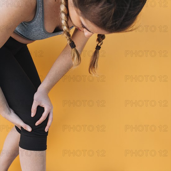 Sporty woman holding injured knee