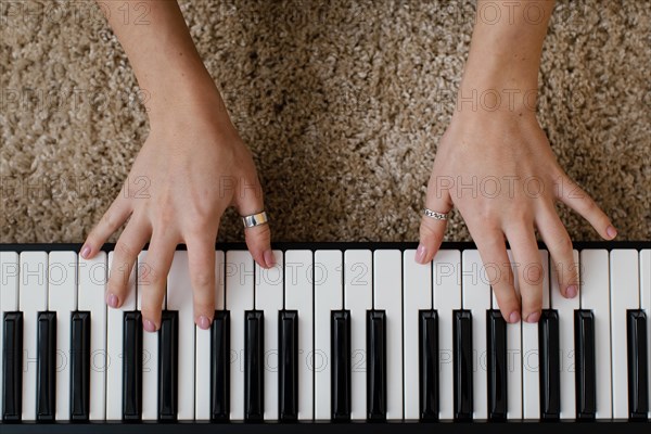 Top view female musician playing piano keyboard