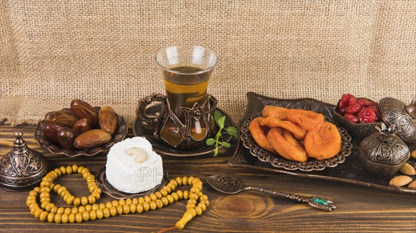 Tea glass with dried fruits beads wooden table