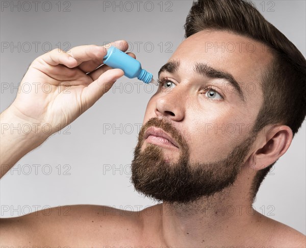 Man using eye drops