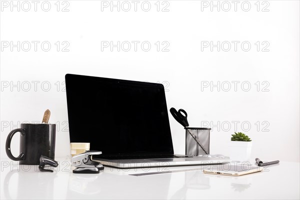Laptop with blank screen cellphone reflective desk