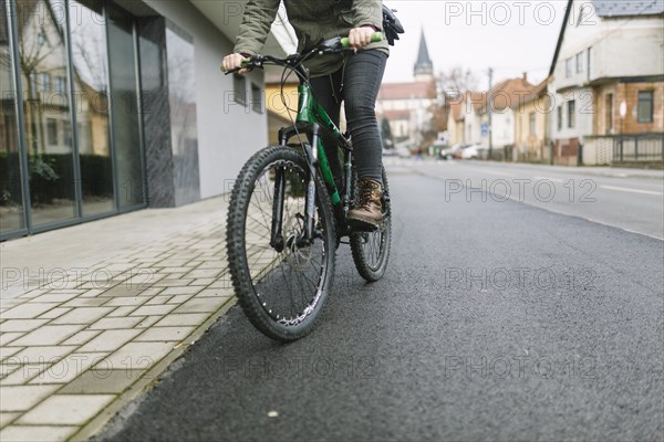Crop woman riding bicycle